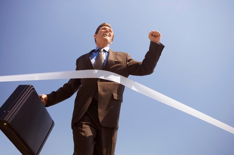 Businessman Crossing the Finish Line --- Image by &copy; Royalty-Free/Corbis